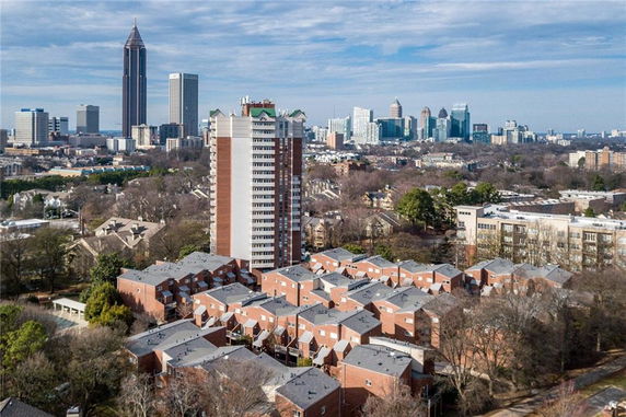 Aerial view of a residential area with apartment buildings and a city skyline in the background.