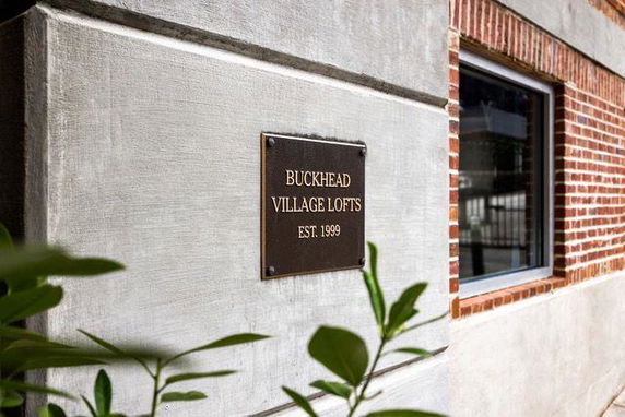 Front view of a building with a plaque reading 'Buckhead Village Lofts EST. 1999'.