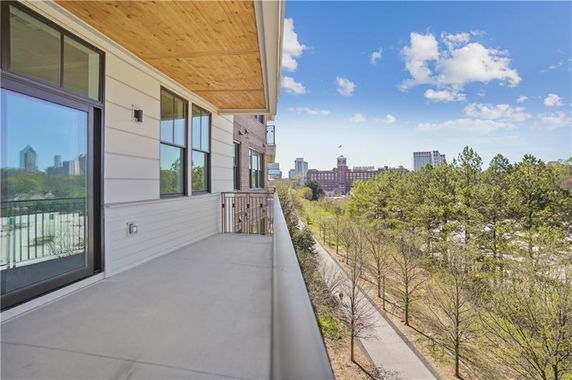 View from a balcony overlooking city skyline and park.