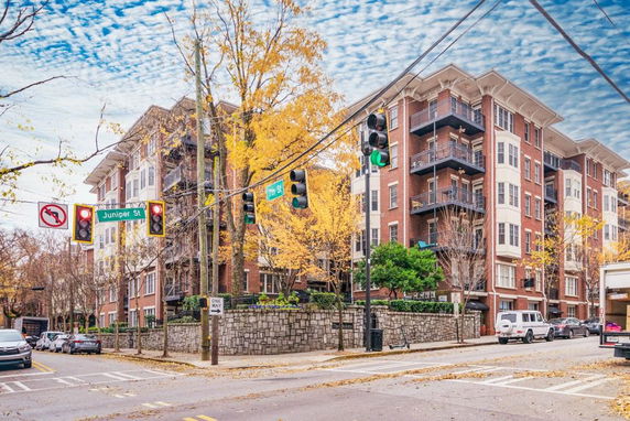 Front view of a multi-story residential building with balconies and brick facade.