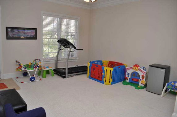 Room with treadmill and children's play area.