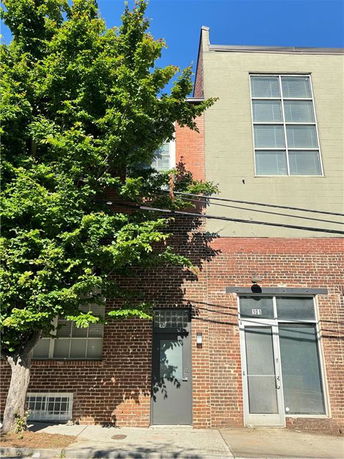 Front view of a two-story brick building with large windows.