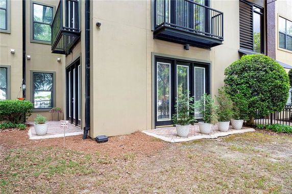 Corner view of a building with balconies and French doors leading to an outdoor area.