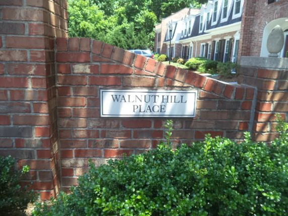 Front view of a residential building with brick exterior and a sign reading 'Walnut Hill Place.'