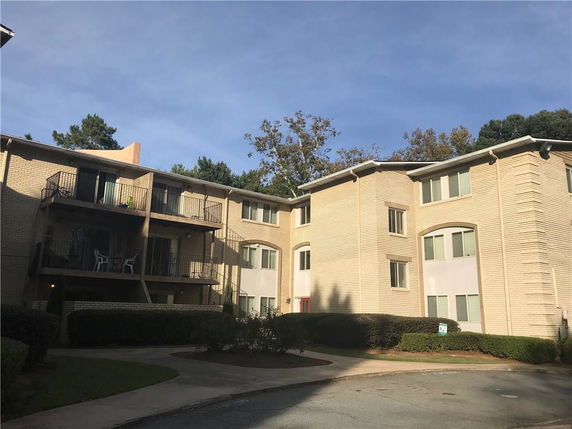 Front view of a multi-story apartment building with balconies.