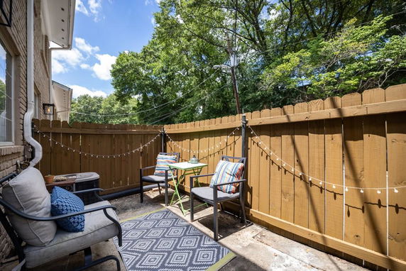 Enclosed outdoor patio area with seating and decorative string lights.