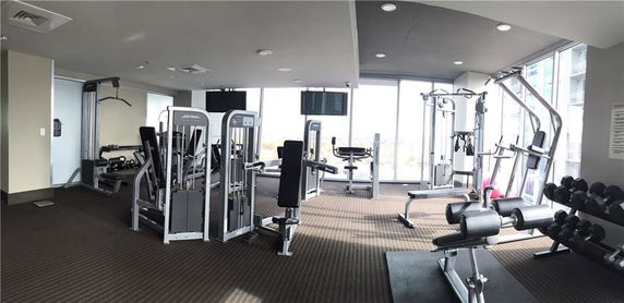 Indoor gym area with various exercise equipment and machines.