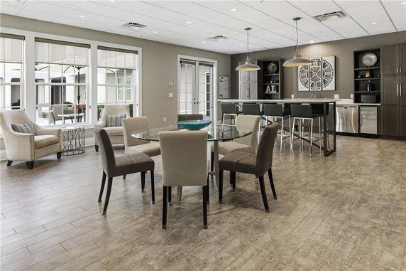 Interior view of a clubhouse recreation area with seating and a bar.