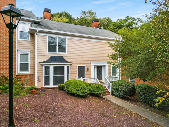 Front view of a two-story townhouse with a small entrance porch.