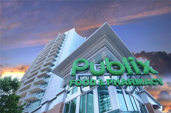 Front view of a modern high-rise building featuring a Publix Food & Pharmacy store.