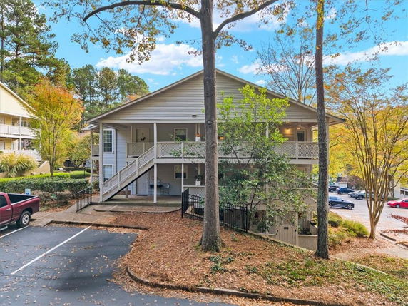 Front view of a two-story building with a covered porch and exterior staircase.