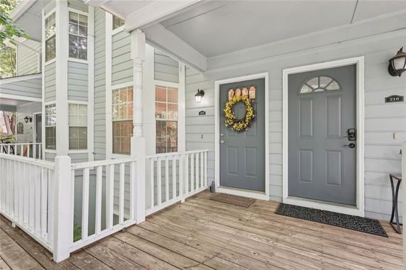 Front view of a house with a wooden porch and double doors.