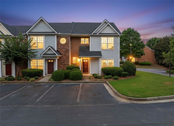 Front view of a two-story townhouse with a brick and siding exterior.