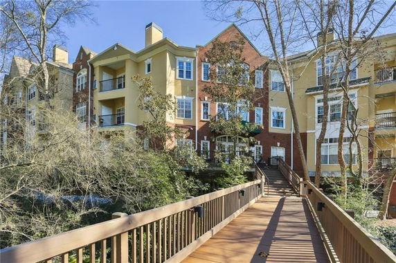 Front view of a multi-story residential building with balconies and a brick facade.