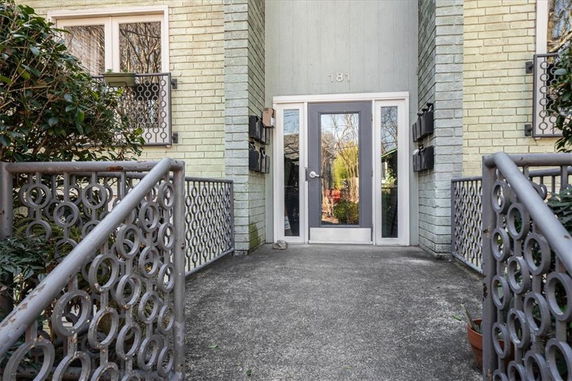 Entrance view of a building with metal railings and glass doors.