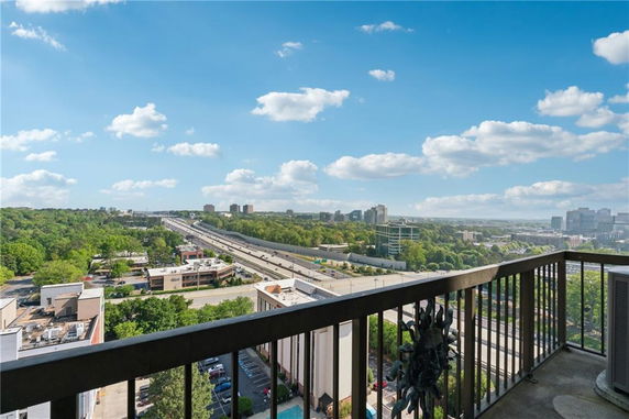 Panoramic view from a balcony overlooking a highway and cityscape.