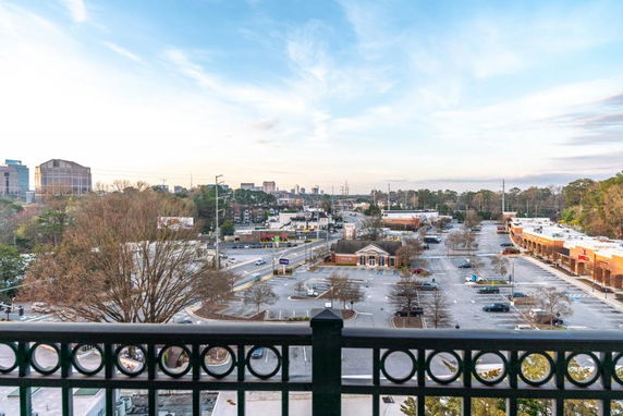 Panoramic view of a cityscape with parking area and buildings visible from a high vantage point.