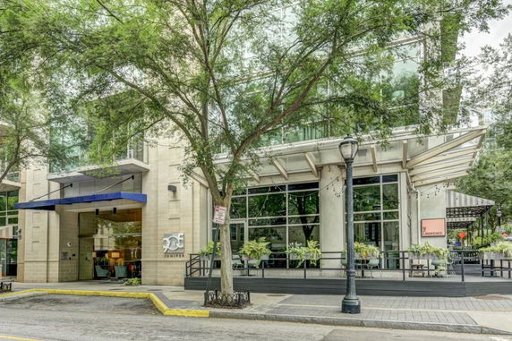 Front view of a modern multi-story building with large glass windows and an entrance canopy.