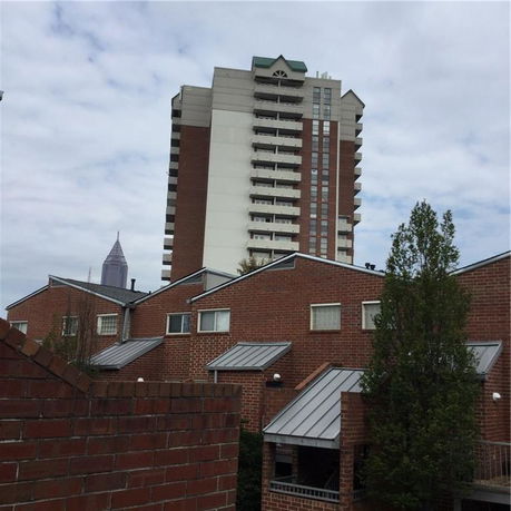 View of a multi-story residential building with brick exterior and balconies.