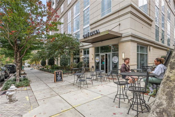 Front view of a building with an outdoor cafe area and seating.