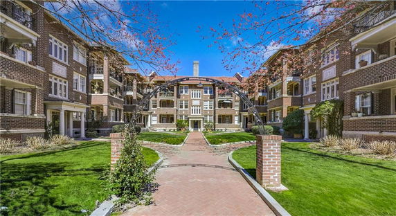 View of a multi-story residential building complex with a courtyard and pathway.