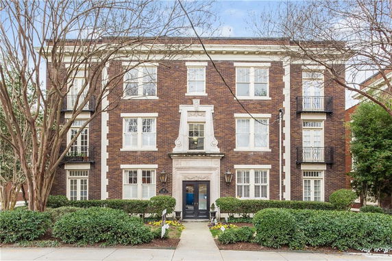 Front view of a three-story brick building with multiple windows and a central entrance.