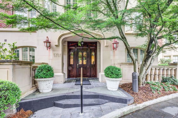 Front view of a building with decorative entrance and potted plants.