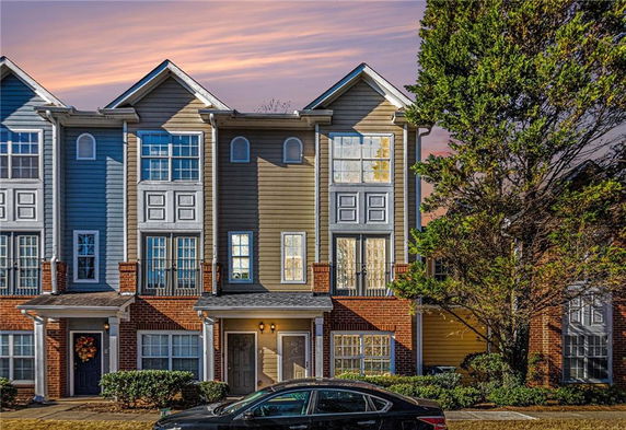 Front view of a multi-story townhouse with a brick and siding exterior.