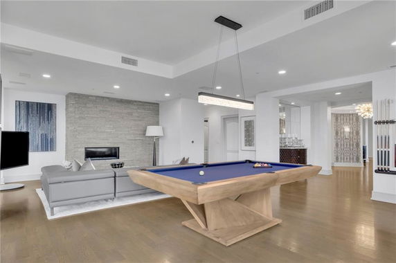 Living area with a billiards table and modern seating arrangement.
