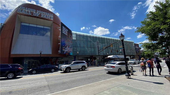 Front view of a modern building with a glass facade, featuring the Hall of Fame.