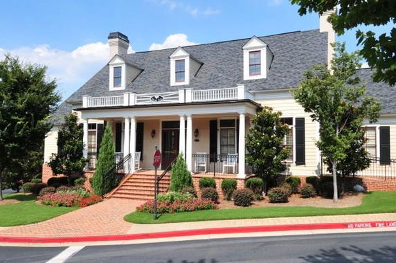 Front view of a house with a porch and dormer windows on the roof.