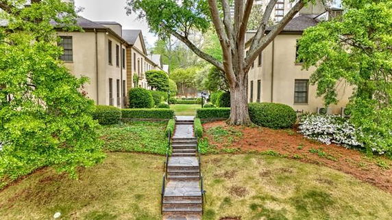 Front view of a two-story residential building with a pathway and landscaped garden.
