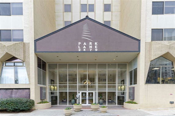 Front view of a building entrance with large glass windows and a canopy.