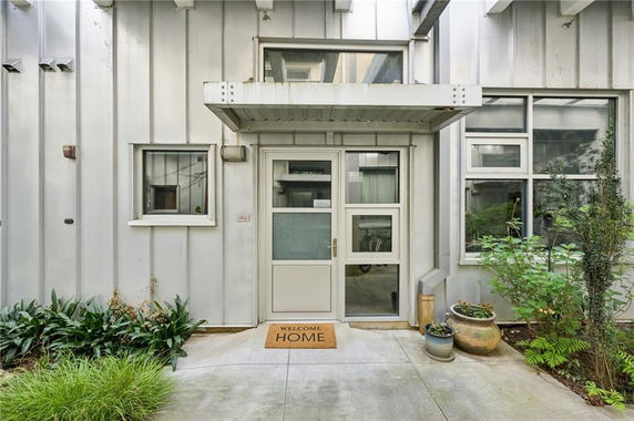 Front view of a house with a metal exterior and glass door entrance.