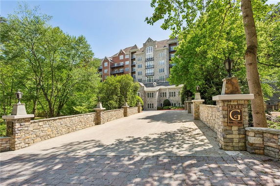 Front view of a multi-story building with stone facade and driveway entrance.