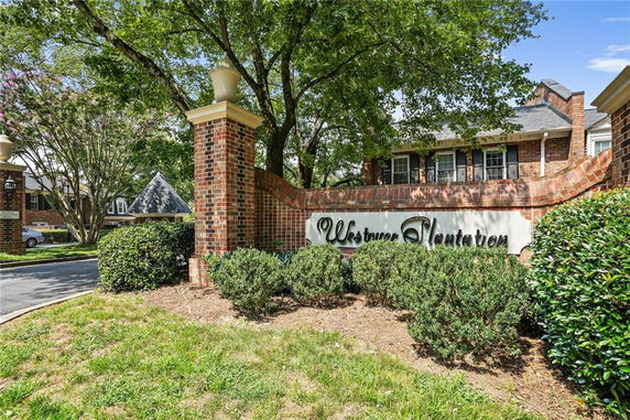 Entrance view of a residential complex with brick pillars and signage.
