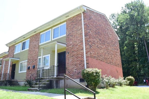Front view of a two-story apartment building with brick and siding exterior.