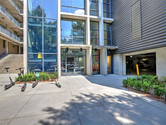 Front view of a modern multi-story building with glass facade and entrance.