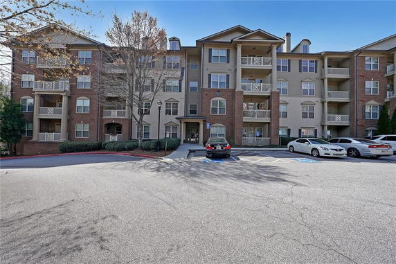 Front view of a four-story residential apartment building with balconies.