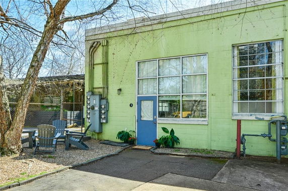 Front view of a green building with large windows and a blue door.