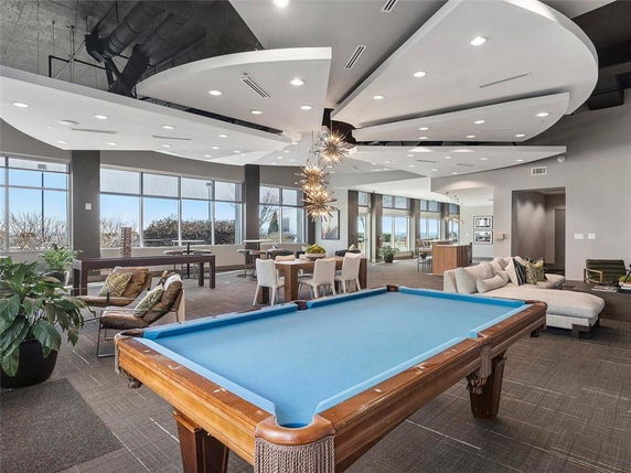 Interior of a recreation area with a pool table and seating.