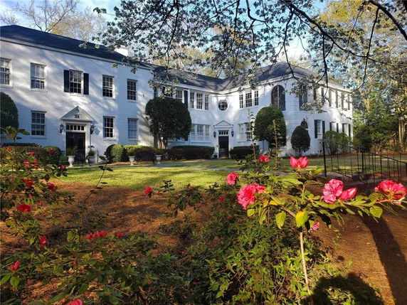 Front view of a large two-story white building with symmetrical windows and entrance.