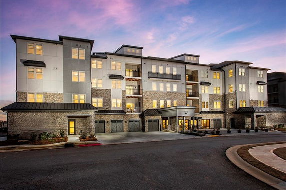 Front view of a multi-story residential building with modern design and numerous windows.