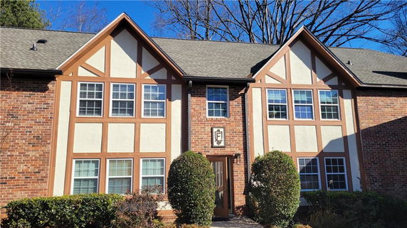 Front view of a two-story house with brick and half-timbered facade.