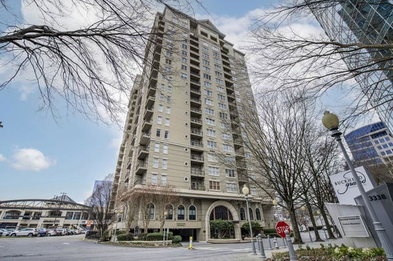 Front view of a tall multi-story building with numerous windows and balconies.