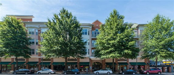 Front view of a multi-story building with commercial spaces on the ground floor.