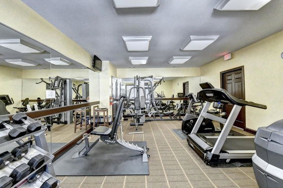 Indoor fitness area with gym equipment and mirrors.