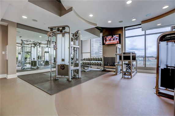 Indoor gym area with exercise equipment and large windows.
