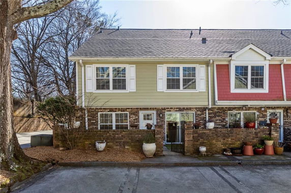 Front view of a two-story townhouse with brick and siding exterior.