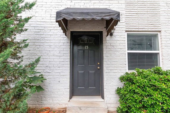 Front view of a building entrance with a black door and an awning.